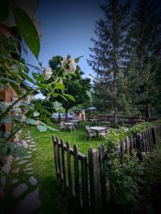 a garden with a wooden fence and a table and flowers at Auberge Saint Antoine in Pelvoux