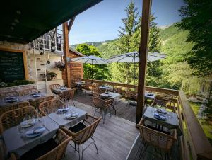 a restaurant with tables and chairs on a wooden deck at Auberge Saint Antoine in Pelvoux