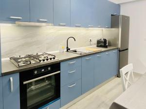 a blue kitchen with a stove and a sink at GREEN STUDIO in Focşani