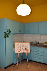 una cocina con armarios azules y un cartel en una mesa en El Otel The Hotel, en El Cairo