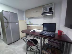 a kitchen with a table with a laptop computer on it at Hostal Ninfa del Mar in Manizales