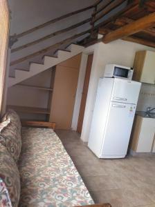 eine Küche mit einem weißen Kühlschrank und einer Treppe in der Unterkunft Cabañas el Ñato in Nono