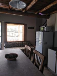 eine Küche mit Tisch und Kühlschrank und einer Couch in der Unterkunft Cabañas el Ñato in Nono