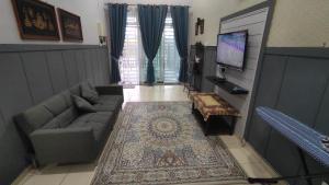 a living room with a couch and a tv at Homestay Ara Kaseh in Mersing