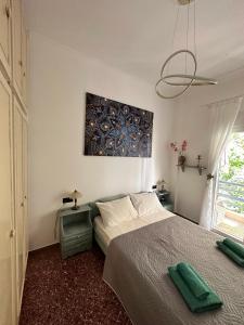 a bedroom with a bed and a painting on the wall at Cozy Flat Loutra Aidipsou in Loutra Edipsou