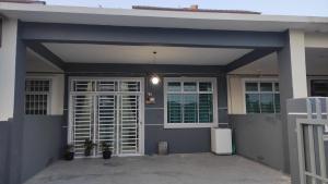 a house with a garage with a white door at Homestay Ara Kaseh in Mersing