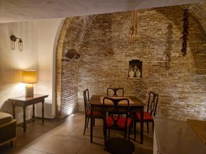 une salle à manger avec une table et un mur en briques dans l'établissement Mary wine house, à Pisticci