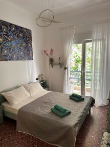 a bedroom with a bed with two green towels on it at Cozy Flat Loutra Aidipsou in Loutra Edipsou