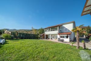 a house with a green lawn in front of it at Apartment Opatija with Garden and Seaview in Opric