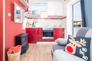 a kitchen with red cabinets and a couch in a room at Apartment Opatija with Garden and Seaview in Opric