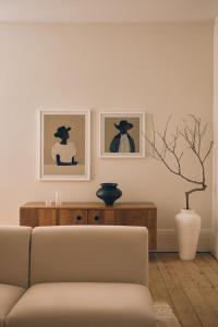 een woonkamer met een bank en twee foto's aan de muur bij Three Rooms Sydney in Sydney