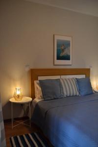 Areia StayInn Beach Apartment في Árvore: غرفة نوم بسرير وطاولة مع مصباح