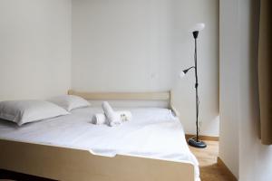 a white bed with two stuffed animals on it at Lovely studio near Panthéon 5th arr of Paris - Welkeys in Paris