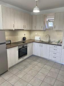 a kitchen with white cabinets and a sink at Villa Lemonia in Malia