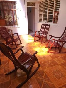 a group of rocking chairs sitting on a floor at Hostel Rossy in San Juan del Sur
