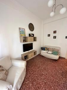 a living room with a couch and a tv at Cozy Flat Loutra Aidipsou in Loutra Edipsou
