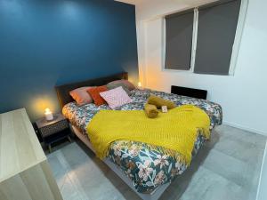 - une chambre avec un lit et une couverture jaune dans l'établissement Le Baroque - plain-pied - 3 chambres - Wi-fi, à Lens