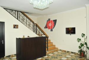 ein Wohnzimmer mit einer Treppe und einem Kronleuchter in der Unterkunft Alma-Ata Hotel in Bordschomi