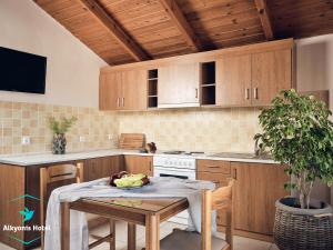 una cocina con armarios de madera y una mesa con bananas. en Alkyonis hotel, en Laganas