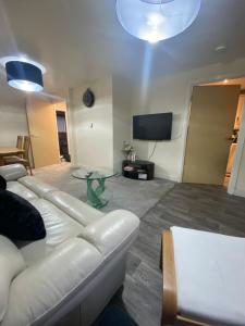 a living room with a white couch and a table at Lovely 2 bed apartment in Crosby in Liverpool