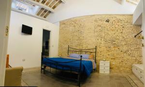 - une chambre avec un lit et un mur en briques dans l'établissement RESIDENZA IN PIAZZETTA, à Vasto