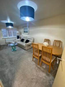 a living room with a table and chairs and a couch at Lovely 2 bed apartment in Crosby in Liverpool