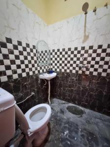 y baño con aseo y lavamanos. en OYO Hotel Raj Residency, en Aligarh