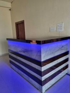 eine Bar in einem Zimmer mit blauen Lichtern in der Unterkunft OYO Hotel Raj Residency in Aligarh