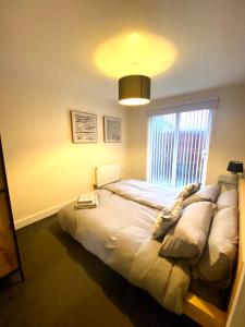 a bedroom with a bed and a large window at Lovely 2 bed apartment in Crosby in Liverpool