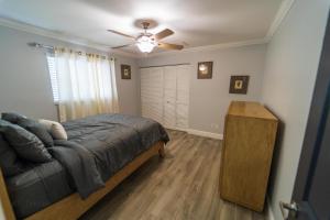 ein Schlafzimmer mit einem Bett und einem Deckenventilator in der Unterkunft Mt Irvine Luxe Pool Cottage/Close to Beach and Equestrian in Florida Gardens + 16 Fotos