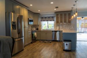 a kitchen with stainless steel appliances and wooden floors at Mt Irvine Luxe Pool Cottage/Close to Beach and Equestrian in Florida Gardens