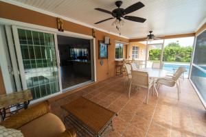 sala de estar con ventilador de techo y mesa en Mt Irvine Luxe Pool Cottage/Close to Beach and Equestrian en Florida Gardens