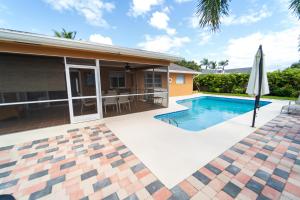 a house with a swimming pool and an umbrella at Mt Irvine Luxe Pool Cottage/Close to Beach and Equestrian in Florida Gardens