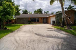 a driveway in front of a house with palm trees at Mt Irvine Luxe Pool Cottage/Close to Beach and Equestrian in Florida Gardens