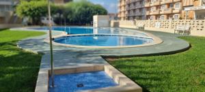 a swimming pool in a yard next to a building at PEÑISMAR AZAHAR in Peniscola