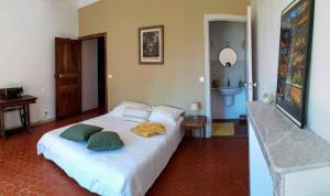 1 dormitorio con 1 cama blanca grande y 2 almohadas en Le Clos du Verger, en La Motte-du-Caire
