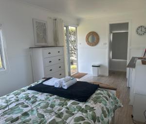 a bedroom with a bed with two towels on it at Stoney Park Holiday Park in Telegraph Point