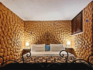 een slaapkamer met een bed met een houten muur bij Appartements Dar Rahma in Chefchaouene