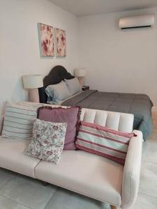 un sofá con almohadas delante de la cama en Quaint and Peaceful Efficiency en Tampa