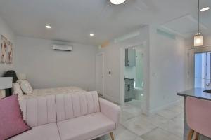 sala de estar blanca con sofá y baño en Quaint and Peaceful Efficiency en Tampa