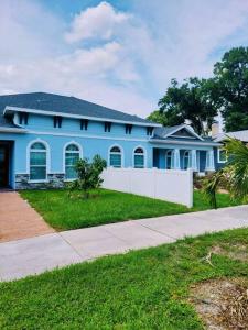 una casa azul con una valla blanca delante de ella en Quaint and Peaceful Efficiency en Tampa