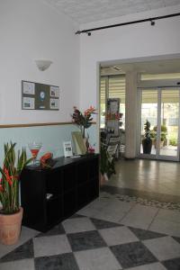 a lobby with a reception desk and potted plants at Hotel Costanza in Cesenatico