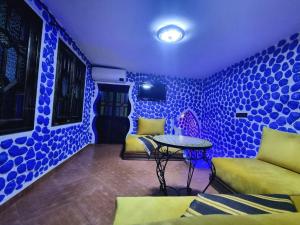 een blauwe kamer met een tafel en een bank bij Appartements Dar Rahma in Chefchaouene +27 foto's