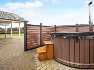 a hot tub sitting next to a wooden fence at 6 person holiday home in Hemmet in Hemmet
