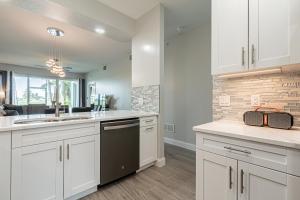 a kitchen with white cabinets and a sink at Greenlinks at Lely Luxury White Orchid Fully Renovated Modern 1st floor 3bdr Golf Resort Villa in Naples