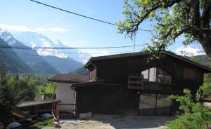 une maison avec un balcon et des montagnes en arrière-plan dans l'établissement Sublime maison 15 personnes, à Saint-Gervais-les-Bains