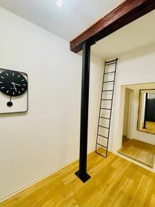 a room with a clock on the wall and a ladder at Großzügiges Loft in zentraler Lage in Braunschweig
