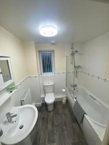 a bathroom with a sink and a toilet and a tub at Lovely 2 bed apartment in Crosby in Liverpool