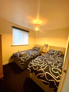 1 dormitorio con 2 camas y ventana en Lovely 2 bed apartment in Crosby, en Liverpool