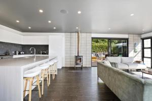 a kitchen and living room with a couch and a fireplace at Lake Tarawera Gem in Rotorua